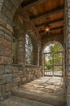 a stone building with an arched doorway and wrought iron fence