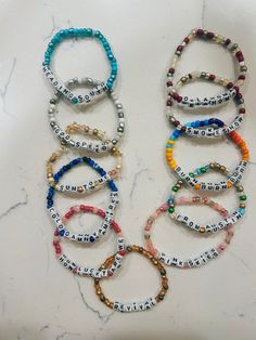 six bracelets with words on them sitting on a counter top next to each other