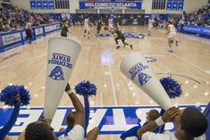 the basketball game is being played with cheerleaders in blue and white pom poms