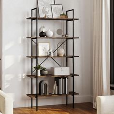 a living room filled with furniture and a book shelf next to a chair in front of a window