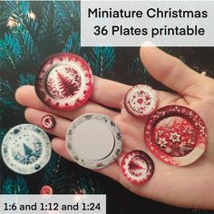 miniature christmas plates are in the palm of someone's hand, which is decorated with red and white designs