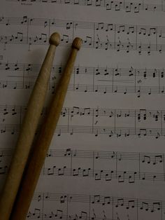 two wooden mallets sitting on top of sheet music