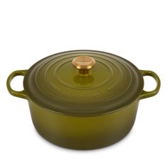 a green casserole with a gold lid