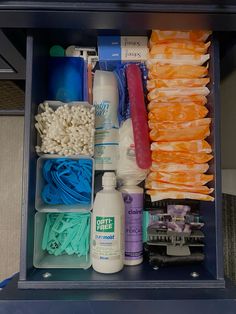 an open drawer with various items in it, including toothbrushes and other hygiene products