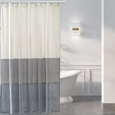 a white bath tub sitting next to a shower curtain with black and white checkers on it