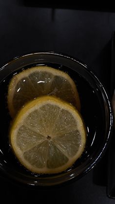 two lemons sitting in a bowl on top of a table