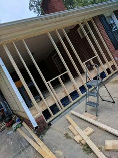 a house that is being built with wooden framing on the front and side walls, including a ladder