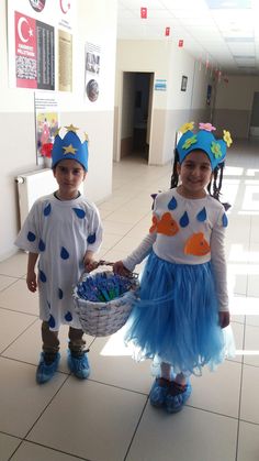 two children dressed up in costumes holding a basket