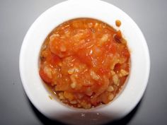 a small white bowl filled with food on top of a table