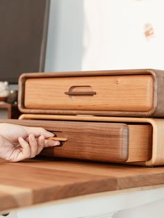 a person is using a cell phone on a table next to some wooden boxes and other items