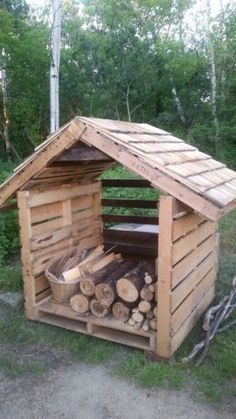 a small wooden shelter with logs in it