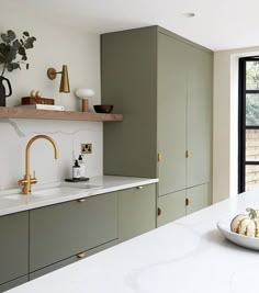 a white counter top in a kitchen next to a sink and window with plants on it