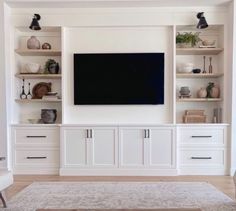 an entertainment center with built in cabinets and a flat screen tv mounted on the wall