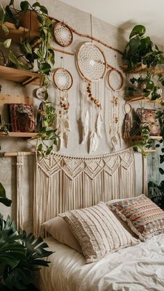 a white bed topped with lots of plants next to a shelf filled with potted plants