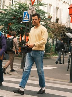 a man walking across a cross walk in the street