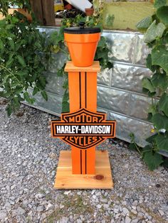 an orange planter sitting on top of a wooden stand