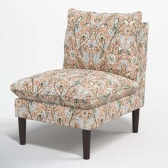 an upholstered chair with a floral pattern on the armrests and legs