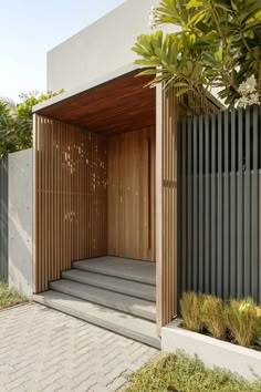 an open wooden door on the side of a building with concrete steps leading up to it