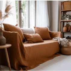 a living room with an orange couch and pillows