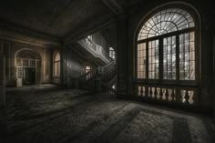 an empty room with large windows and stairs