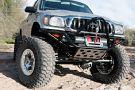 the front end of a silver truck with large tires