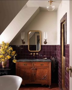 the bathroom is decorated in purple and gold with an interesting mirror on the wall above the sink