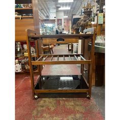 a wooden cart sitting in a store filled with shelves and other items on top of carpeted flooring