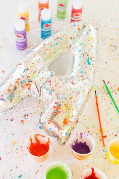 an inflatable balloon sitting on top of a table filled with paint