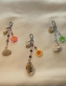 four charms with flowers and shells hanging from them