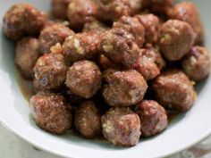 a white bowl filled with meatballs on top of a table