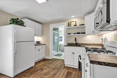 a white refrigerator freezer sitting inside of a kitchen next to a stove top oven