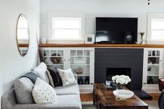 a living room filled with furniture and a flat screen tv mounted on the wall above a fireplace