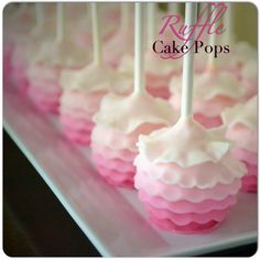 pink and white cake pops are on display