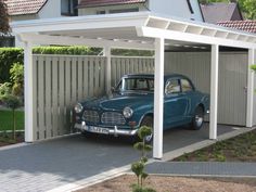 an old car is parked in a carport with a white awning over it