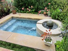 an outdoor hot tub surrounded by plants and flowers