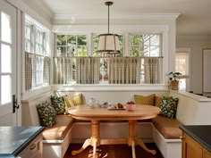 a kitchen with a table and bench in it