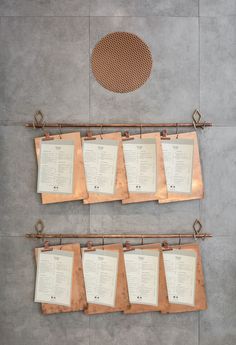 several menus are hanging on the wall next to a grate and strainer