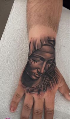 a man's hand with a tattoo on it that has an image of a buddha