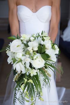 a bride holding a bouquet of white flowers