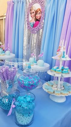 there are many desserts on the table at this princess birthday party, including cupcakes and candy