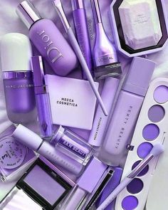 purple makeup and cosmetics products are arranged on a white sheet with the words dior written in it