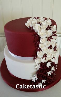 a red and white wedding cake with flowers on top