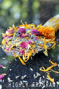 a spoon full of flowers sitting on top of a table