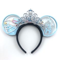 a blue mickey mouse ears headband with an image of disney's castle on it