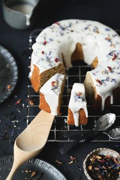 a bundt cake with white frosting and sprinkles on a cooling rack