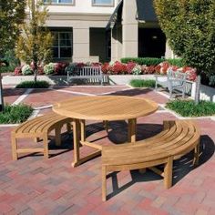 a wooden table and benches in front of a house