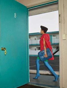 a woman in blue tights is walking out of an open door with her handbag