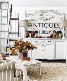 a living room filled with furniture and a large sign on the wall above it that says antiques i blog