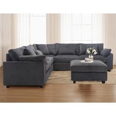 a living room with a sectional couch and ottoman