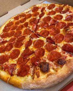 a pepperoni pizza sitting on top of a box